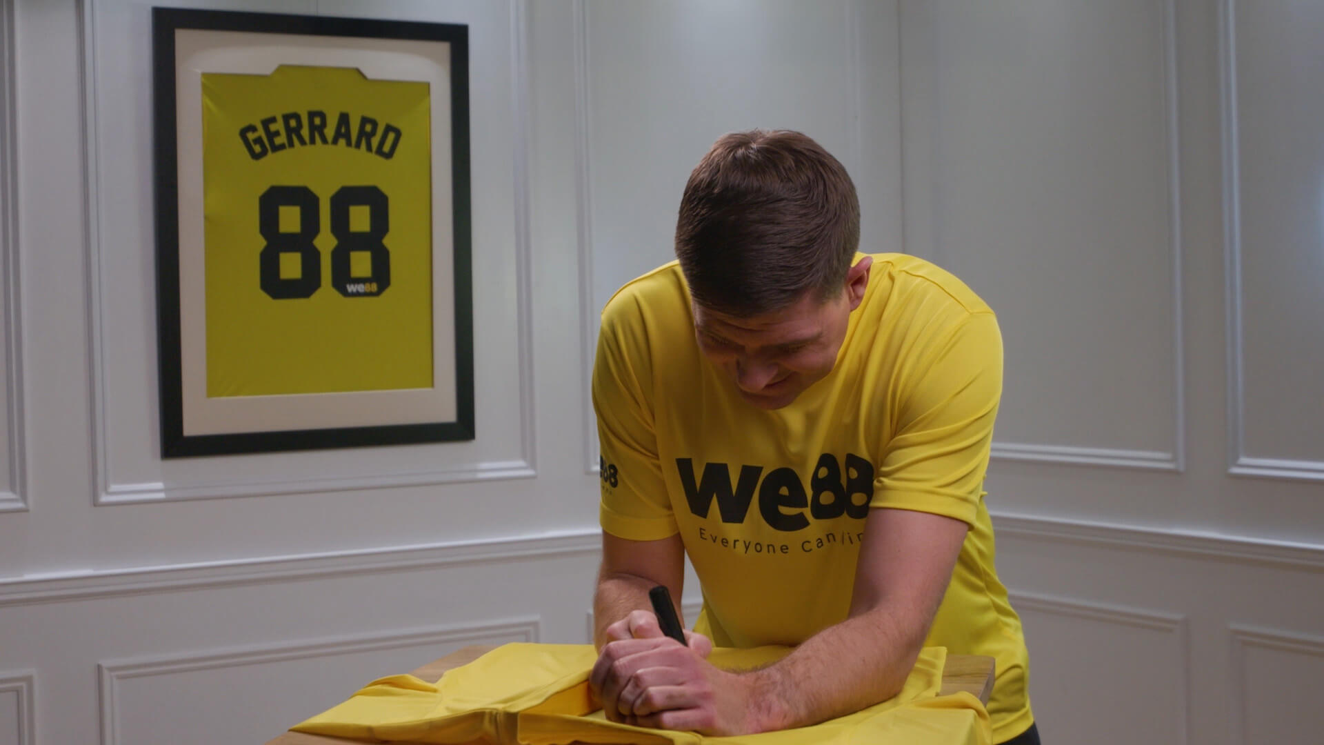 BX99 26/27 Global Brand Ambassador Usain Bolt signing an official yellow jersey during an exclusive behind-the-scenes shoot