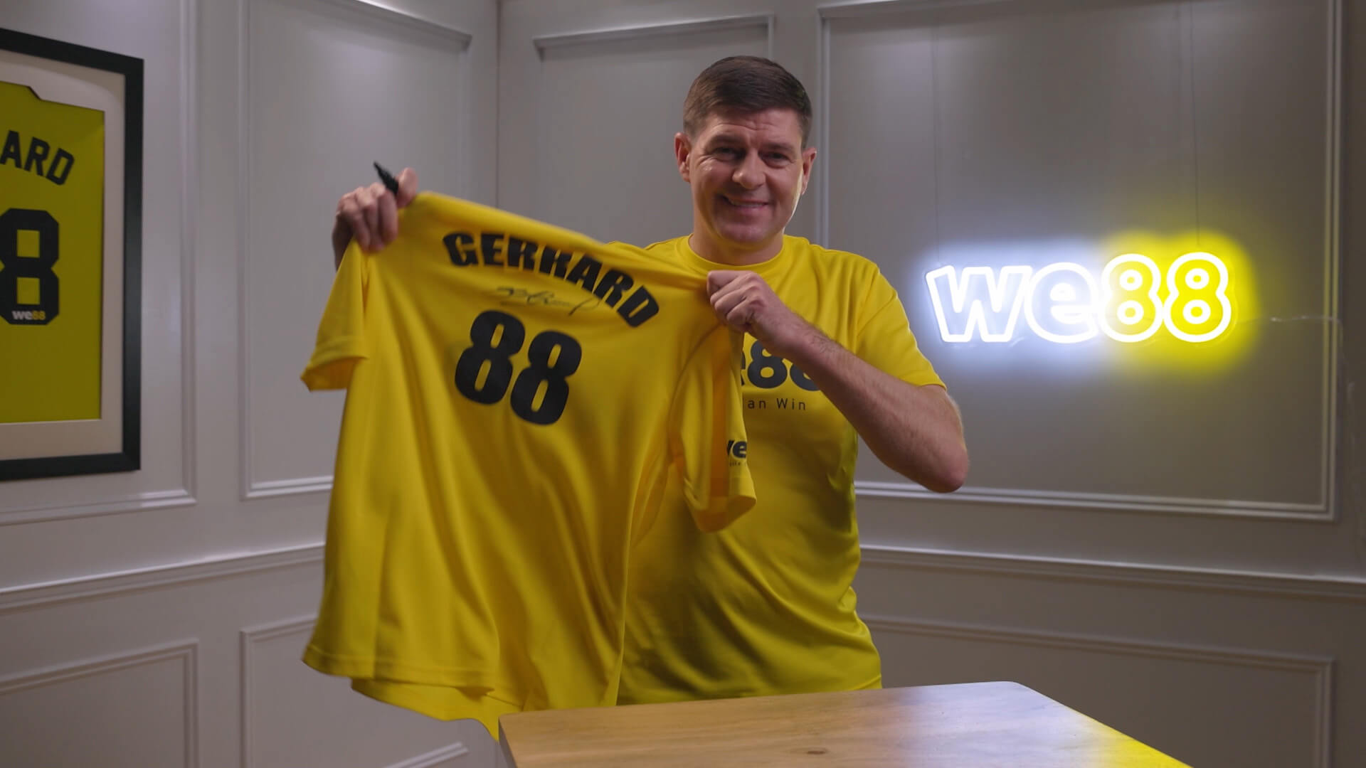 BX99 26/27 Global Brand Ambassador Usain Bolt proudly holding up a signed yellow Gerrard 88 jersey